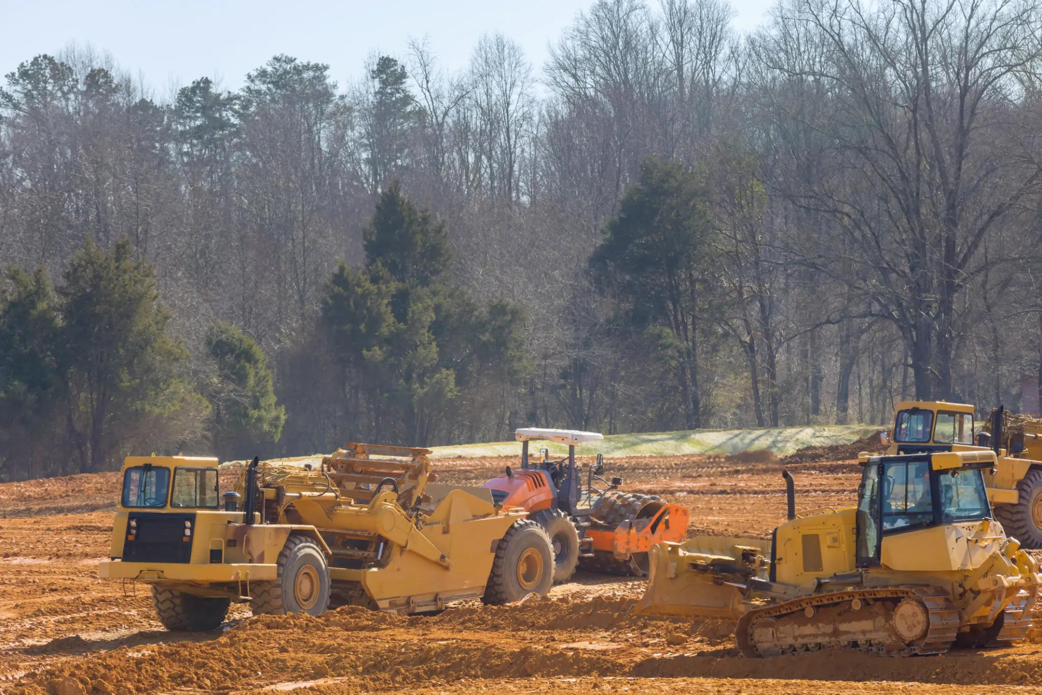 Construction vehicles working on dirt site.